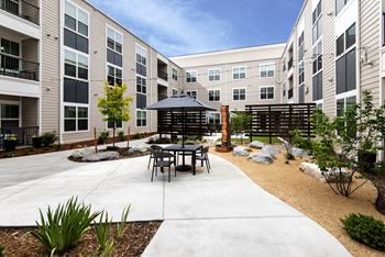 An outdoor patio with tables and chairs in an apartment building
